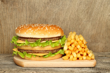 Hamburger and french fries on old wooden background