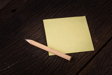 Pencil and blank notepad for new note message on table.