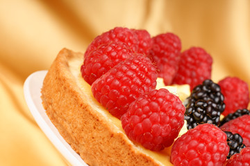Close-up of a custard tart with raspberries and blackberries