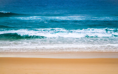 Fototapeta na wymiar Turquoise Ocean with white waves and yellow sand at the beach. East Coast Australia.