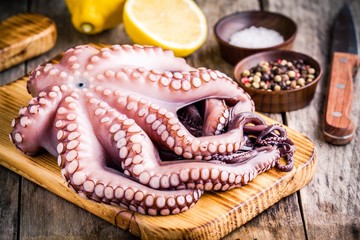 fresh octopus in the bowl with lemon, sea salt and pepper