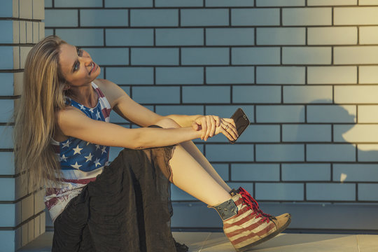 Female model on the background of a building in a t-shirt with a