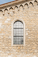 Arched window in the ancient stone wall