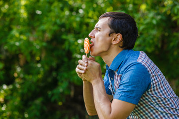 The man in the street holding a lollipop on a green background  