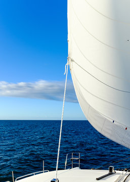 Sail Full of Wind under a blue sky on the ocean