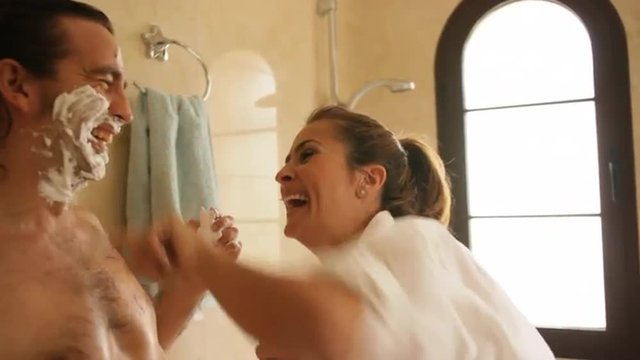 Couple in bathroom, man shaving