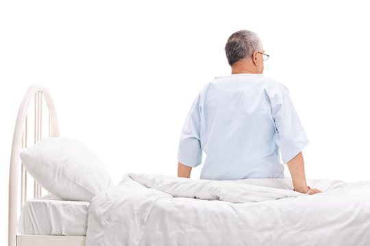 Senior Patient Sitting On A Hospital Bed