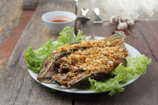 Fried Snapper with Garlic and Pepper on wood table.