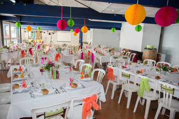 Table setting for an wedding reception in orange, pink and yellow color