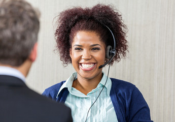 Happy Female Customer Service Executive Looking At Manager