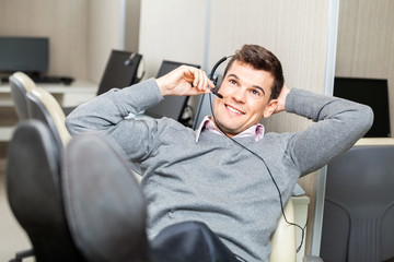 Fototapeta premium Smiling Customer Service Representative Adjusting Headset With L