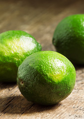 Fresh limes on an old wooden table, selective focus