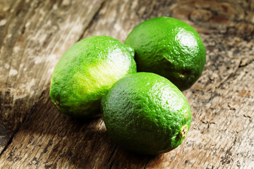 Fresh limes on an old wooden table, selective focus