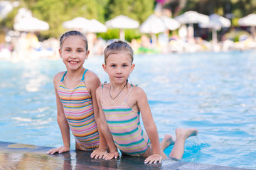 Two cute little girls in swimming pool