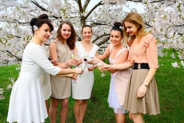 Girls with champagne celebrating in sakura's garden.