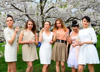 Girls with champagne celebrating in sakura's garden.