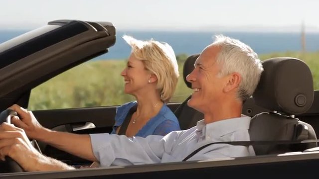 Senior Couple Driving Convertible Car