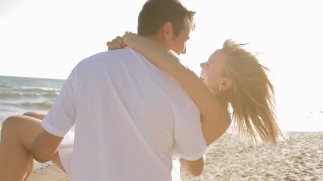 young couple twirling on beach