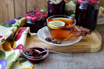 Plate with cherry jam and a cup of tea..