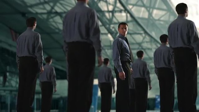 Group of businessmen, on of them turns to camera. 