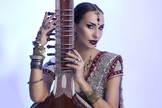 Beautiful Indian Woman in Sari with Oriental Jewelry Posing with