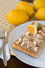 Waffles with meringue, lemon curls and orange slices