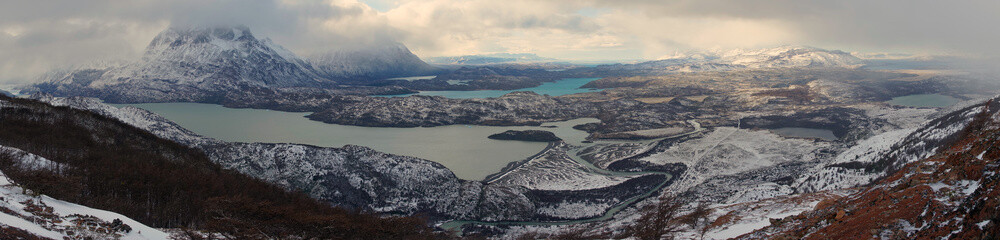 Winter landscape of lakes and snow covered hills and mountains in Torres del Paine National Park in Patagonia, Chile.