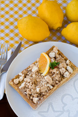 Waffles with meringue, lemon curls and orange slices 