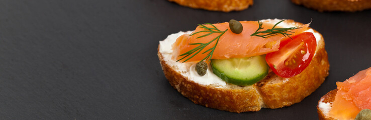 Finger food canapes with smoked salmon and cream cheese. Selective focus.