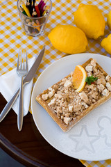 Waffles with meringue, lemon curls and orange slices