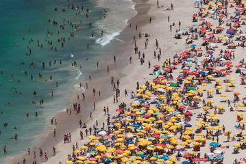 Aerial view at crowded beach with umbrellas in tropical climate. Tourists on Ipanema beach in Rio...