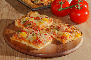 Pizza mit Paprika, Tomaten, Schinken, Zwiebeln, Käse