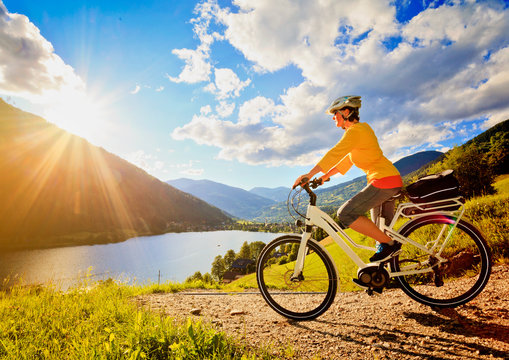 woman with e-bike above a lake in sunset/e-power 11