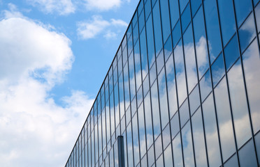 Fototapeta na wymiar Reflection of the sky and clouds in Glass facade of a building in Poznan .
