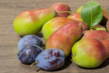 Still life of ripe juicy pears and plums