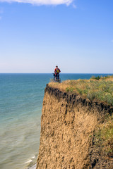 Obraz premium cyclist on a cliff above the sea