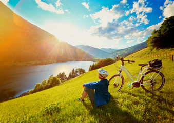 woman resting above a lake with her e-bike/e-power 14