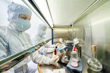workers in protective uniform at laboratory