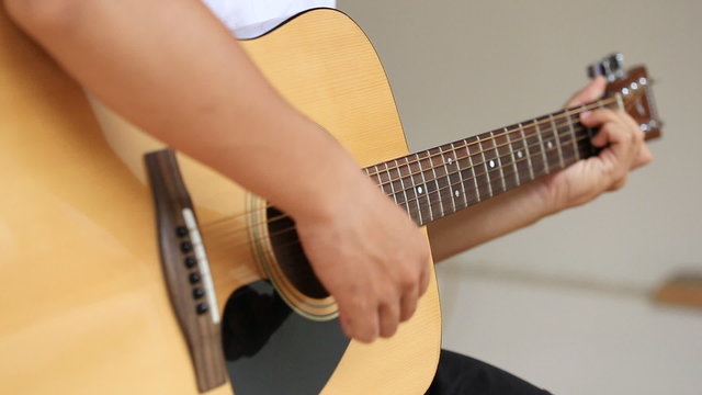Close up of hand playing acoustic guitar 