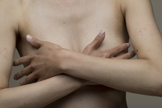 Young woman hiding breast by hand