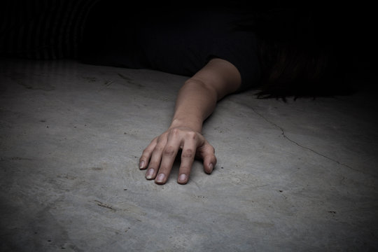 The dead woman's body. Focus on hand