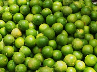 Lot of fresh green limes closeup fruit background.
