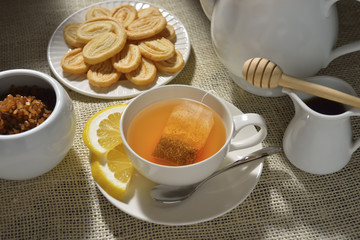 Cup of tea with lemon and cookies on table