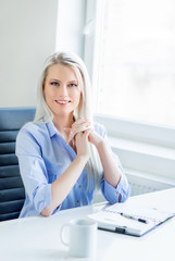 Young, attractive and confident business woman working in office