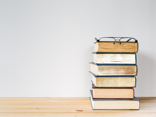 A lot of books for studying and black glasses