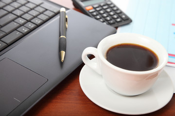 Calculator and cup of coffee on the financial documents