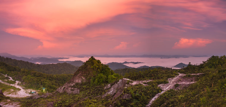 Fototapeta red light over sea fog mountain