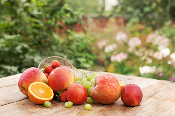 Fresh fruits, on wooden table, on green background