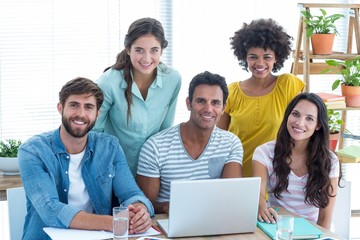 Colleagues using laptop at office