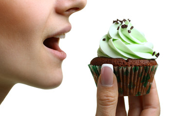 closeup of woman eating chocolate cupcake